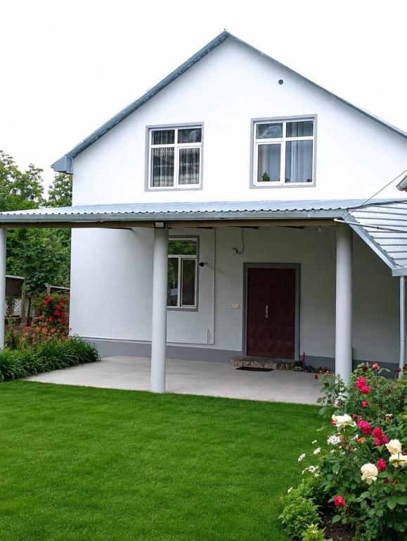 a white house with a lawn in front of it at Shahdag Beloved Home in Qusar