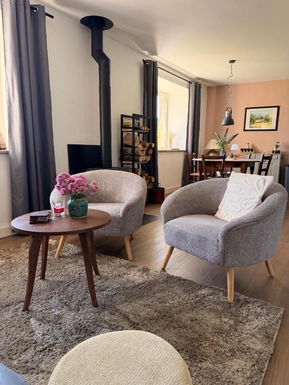 a living room with two chairs and a table at Chateau de Salorges - Farmgite in Corancy