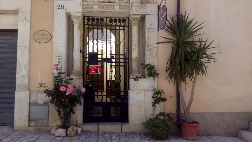 wejście do budynku z czarnymi drzwiami z kwiatami w obiekcie Elianthos B&B w mieście Ispica