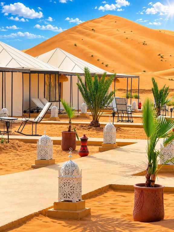 a building in the middle of a desert with palm trees at Sahara Gift camp in Merzouga