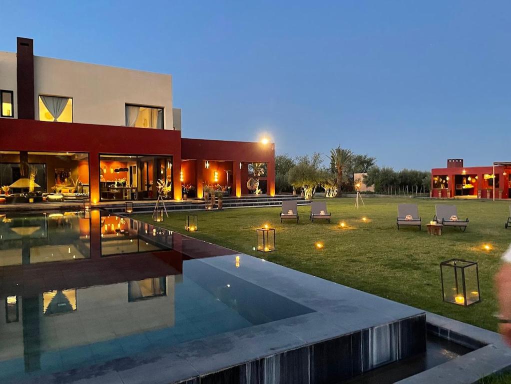 a house with a swimming pool in front of it at DAR NOUJOUM in Marrakesh