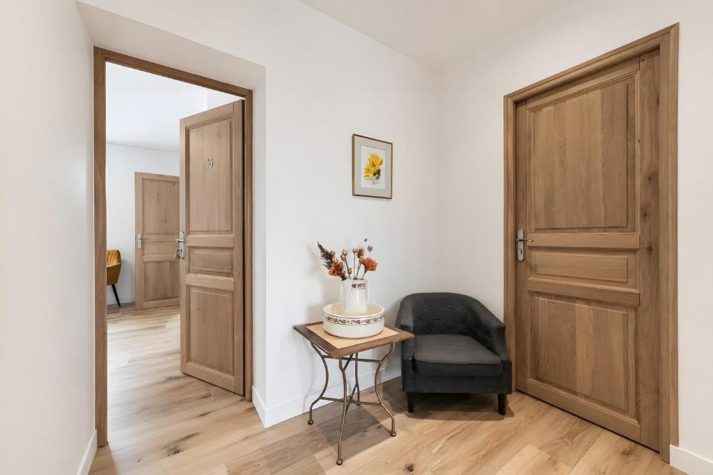 a hallway with a door and a chair and a table at Le Bellevue in Excénevex