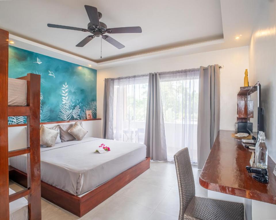 a bedroom with a bed and a ceiling fan at Yellow Mango Resort Bohol in Panglao Island