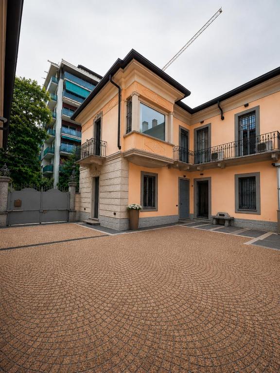 a large house with a brick driveway in front of it at La Villa Del Parco in Monza