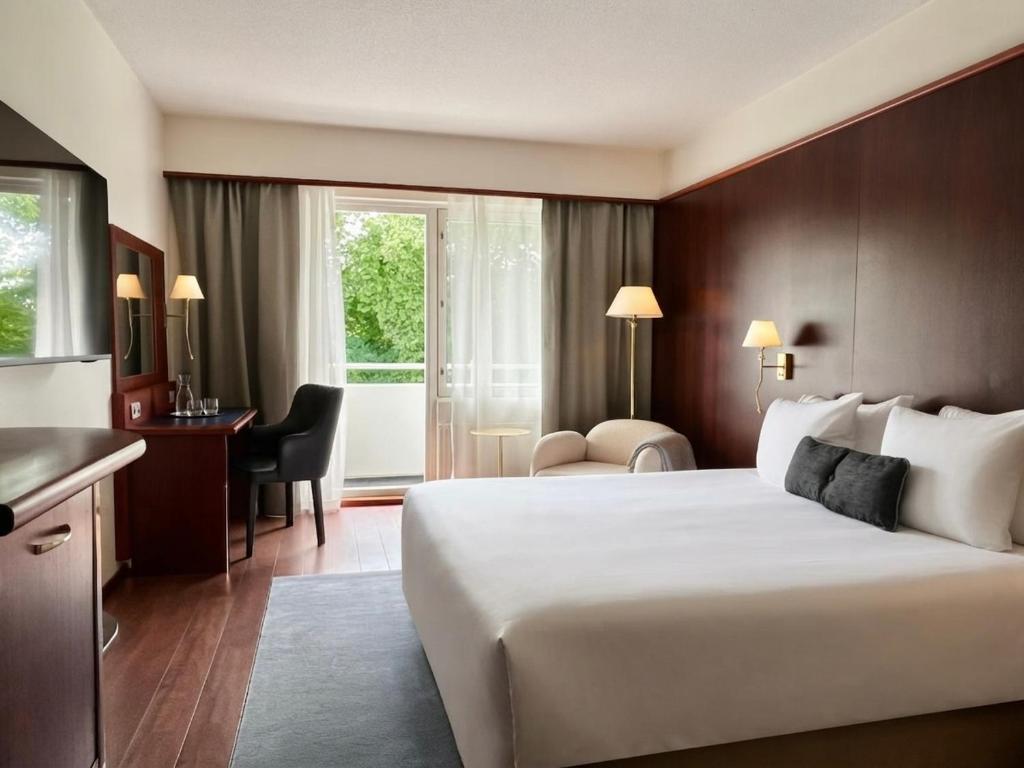 a hotel room with a large bed and a desk at Hotel Kalliohovi - ilmastoidut huoneet - in Rauma