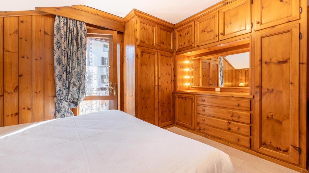 a bedroom with wooden cabinets and a bed at Casa Amabile in Cortina dʼAmpezzo