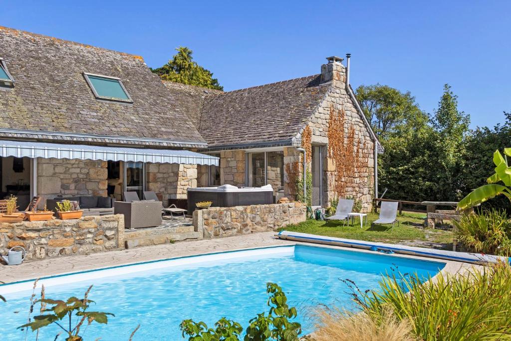 a house with a swimming pool in front of a house at Maison Bringwiller Plage 200m in Trégastel