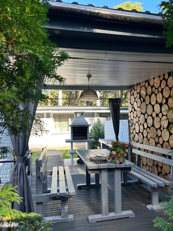 a wooden deck with a picnic table and a grill at Silumetras in Ventspils