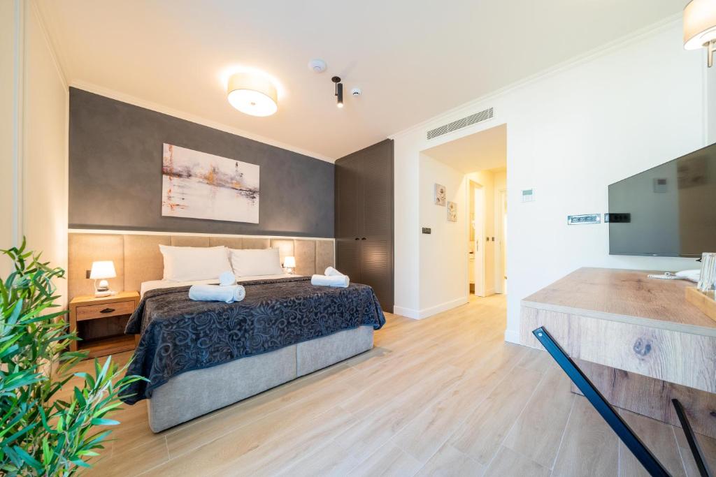 a large bedroom with a bed and a bath tub at Hotel Casa di Petra in Bečići