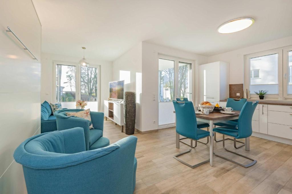 a dining room with blue chairs and a table at FeWo Tommy in Zirchow