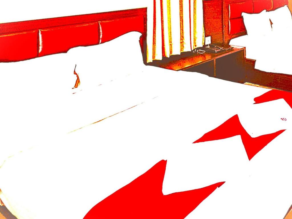 a bedroom with a red bed with two arrows at The B And D Hotel in Guwahati