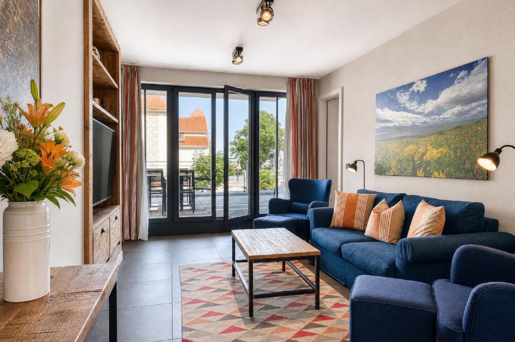 a living room with a blue couch and a table at Ferienwohnung Strandperle in der Villa Martha Binz in Binz