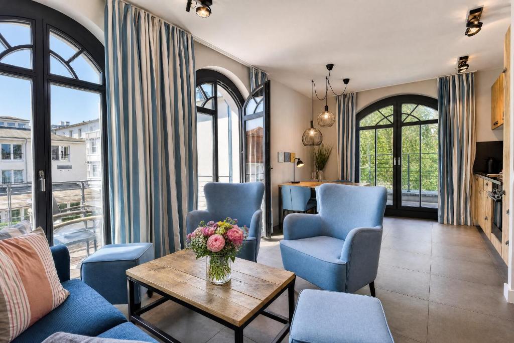 a living room with blue chairs and a table at Ferienwohnung Sandbank in der Villa Martha Binz in Binz