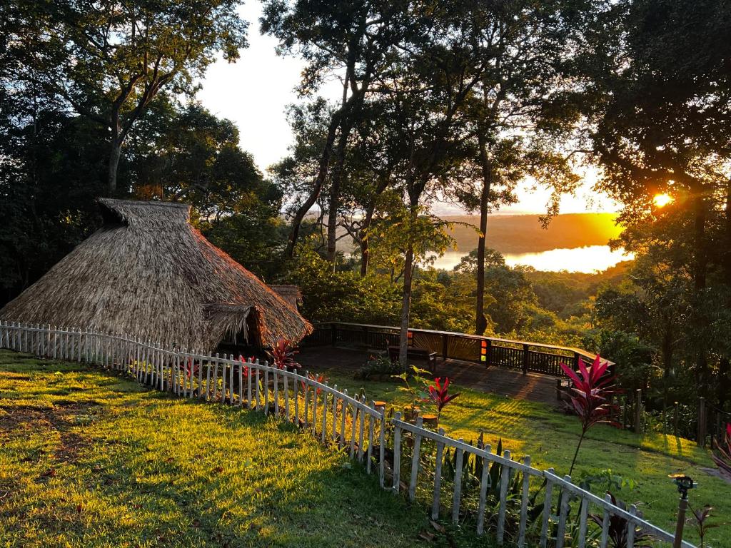 a house with a grass roof with a fence at TerrAmor Ecoliving in Alter do Chao