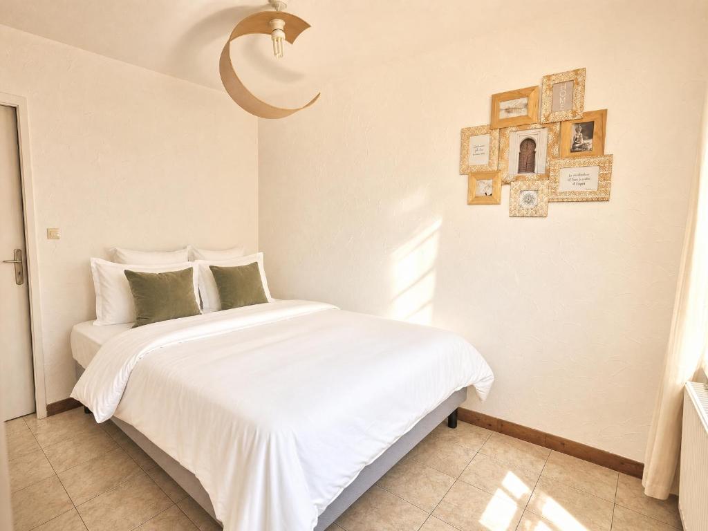 a bedroom with a bed with white sheets and green pillows at Refuge Gaillard Tramway in Gaillard