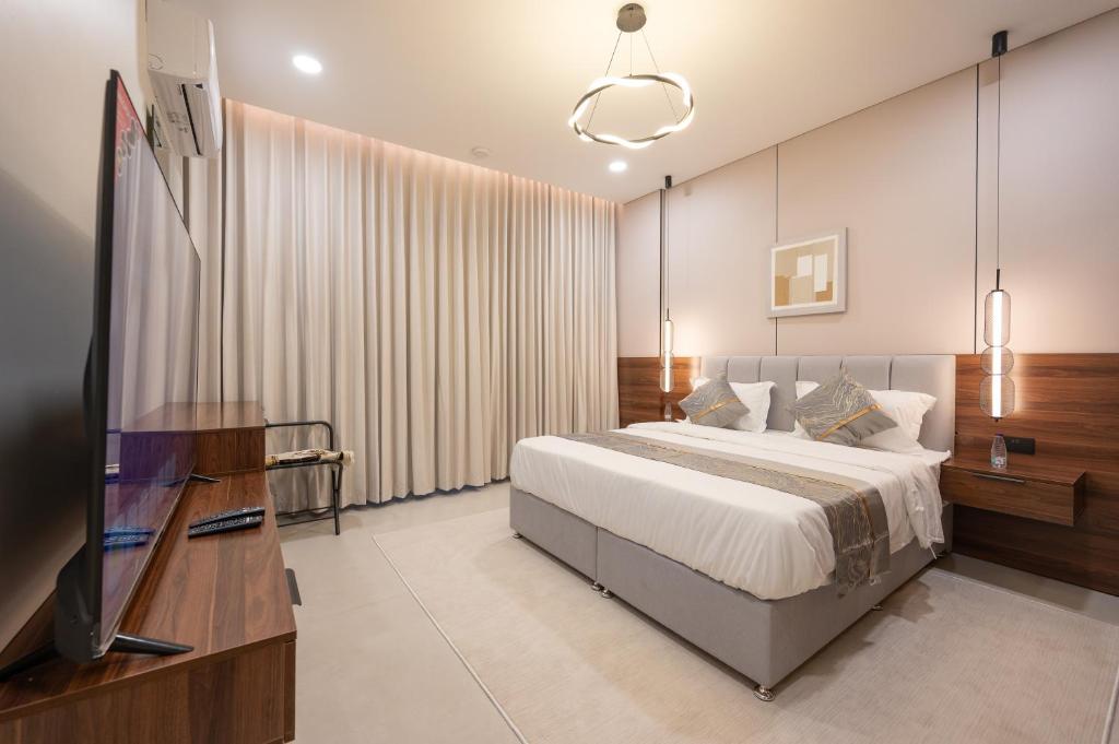 a bedroom with a bed and a flat screen tv at الاخشبان in Jeddah