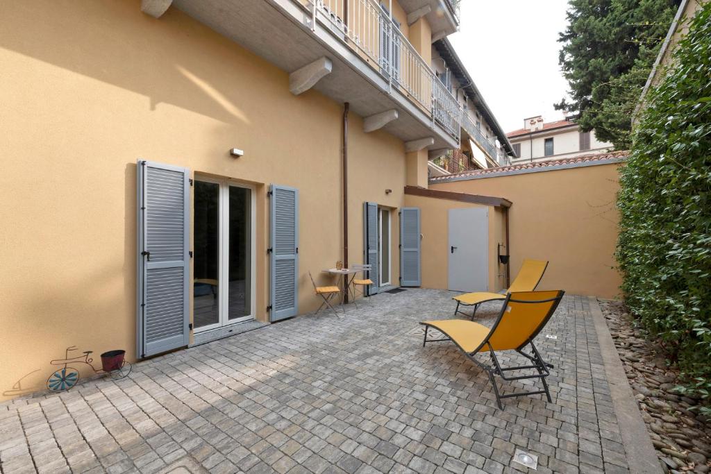 a patio with two chairs and a table and a building at Casa Vacanze Regina in Lecco