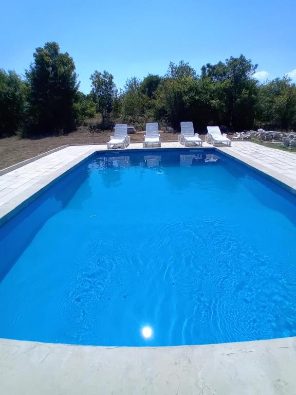 a large blue swimming pool with lounge chairs on top at Amra in Počitelj