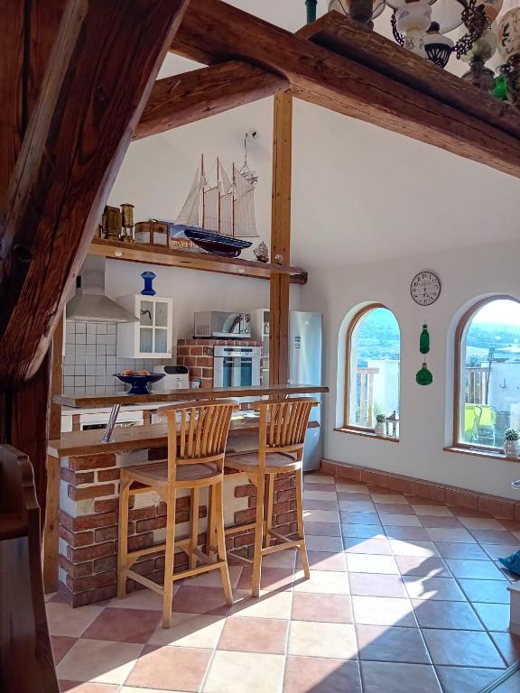 a kitchen with a table and chairs and two windows at Apartmán Merkur in Kadaň