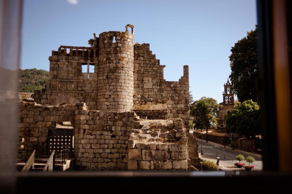 an old stone castle with a street in front of it at O Recuncho do Castelo in Ribadavia