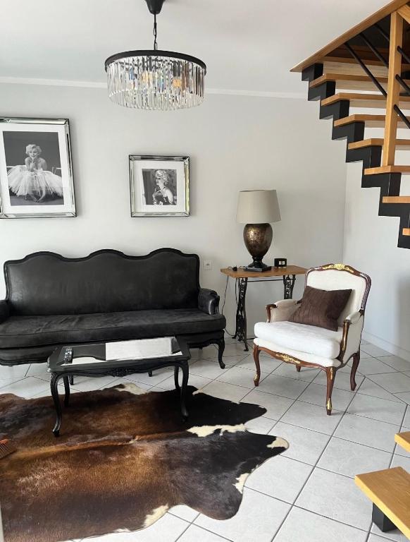 a living room with a black couch and a chair at Pokoje J&J in Grabówka