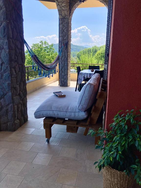 a porch with a bed and a table on a balcony at La Quiete in Caraglio