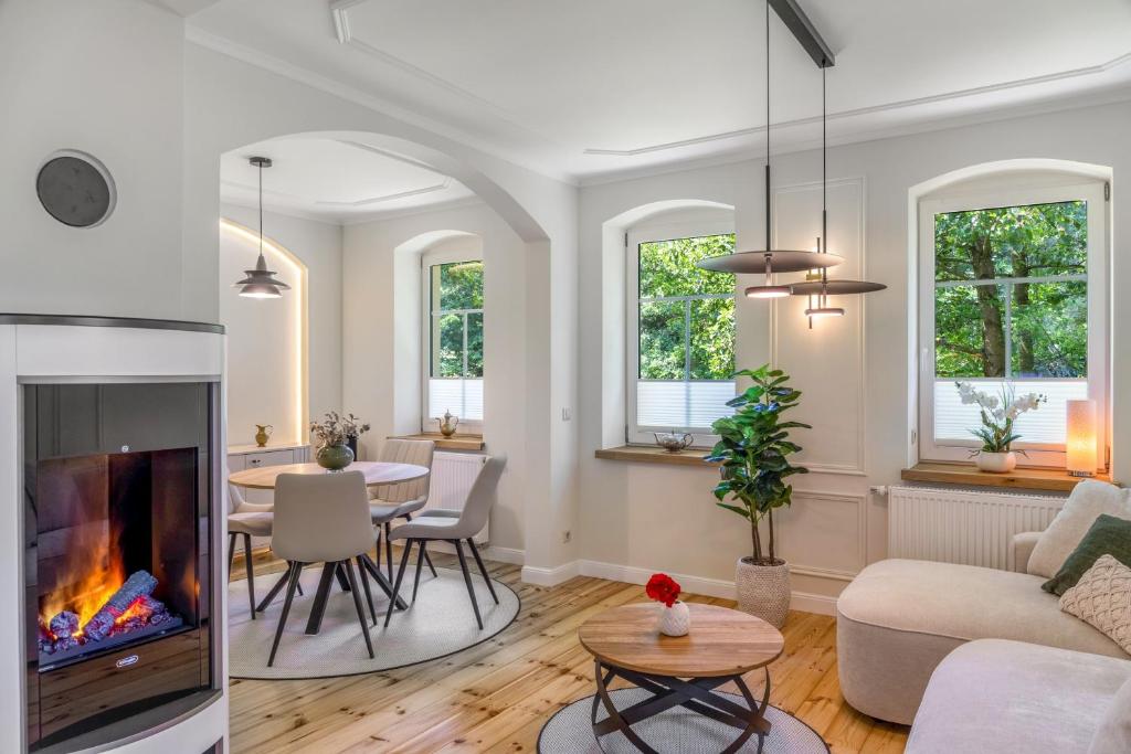 a living room with a fireplace and a table at Ferienwohnung Schwarzmühle 2 in Neuer Anbau
