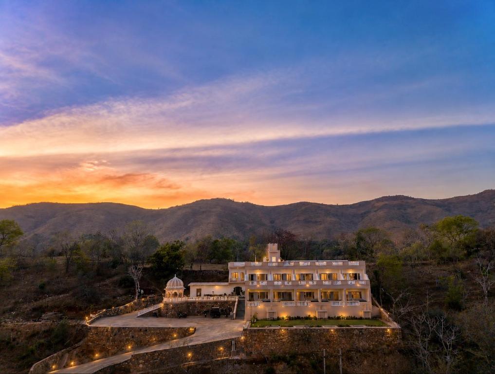 an aerial view of a building with mountains in the background at JD Tara Resort in Ranakpur