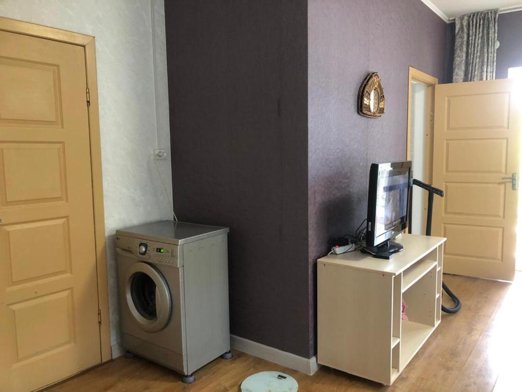 a laundry room with a washing machine and a tv at Чолпон-Ата Коттедж in Cholpon-Ata