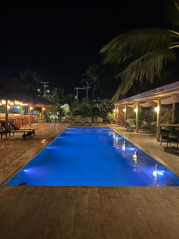 a large blue swimming pool at night at Paraiso da Barra in Barra Grande