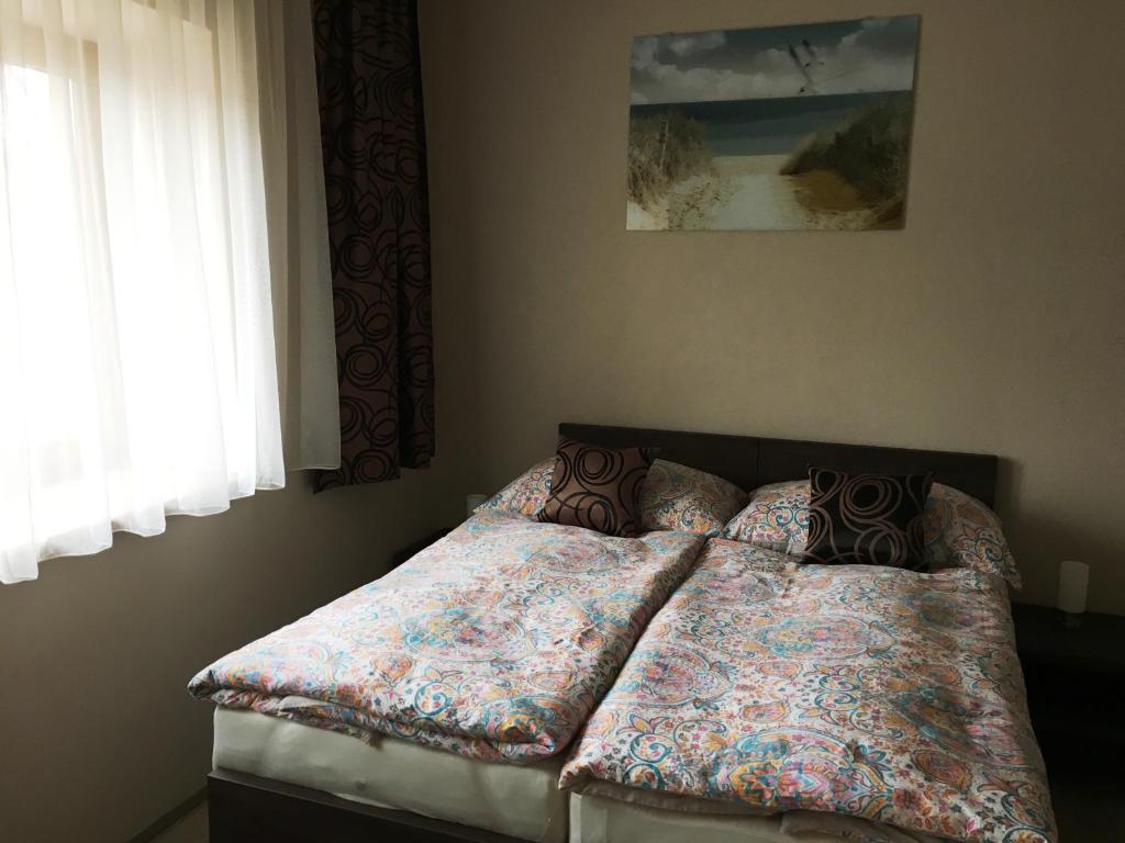 a bedroom with a bed with two pillows on it at Penzion Pikolo in Nové Mesto nad Váhom