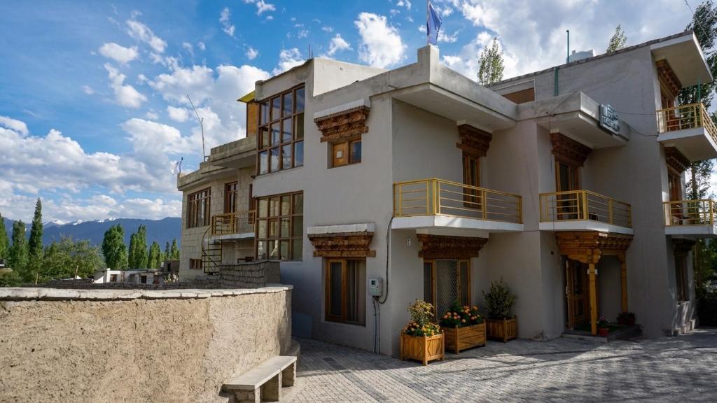 a large white building with balconies on it at Green View Hotel in Leh