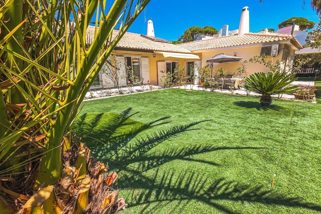 a house with a yard with green grass at Casa da Palmeira in Sesimbra