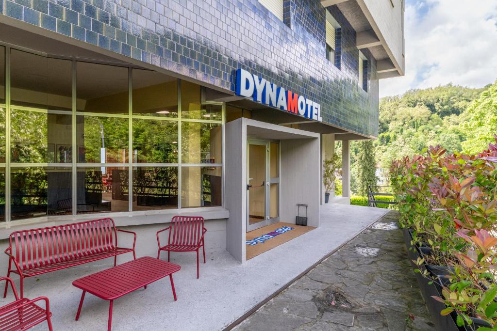 a building with two red benches in front of it at Dynamotel in San Marcello Pistoiese