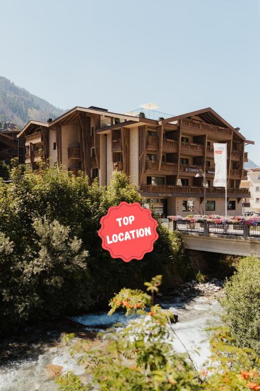 un panneau d'emplacement principal devant un bâtiment dans l'établissement Hotel COSMEA - Your Dolomites & Honeymoon experience, à Ortisei