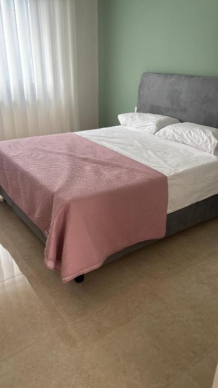 a bed with a red blanket on top of it at Stellarium House in Vibo Valentia