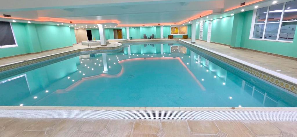 a large swimming pool with blue water in a building at Hustyns Hotel in Wadebridge