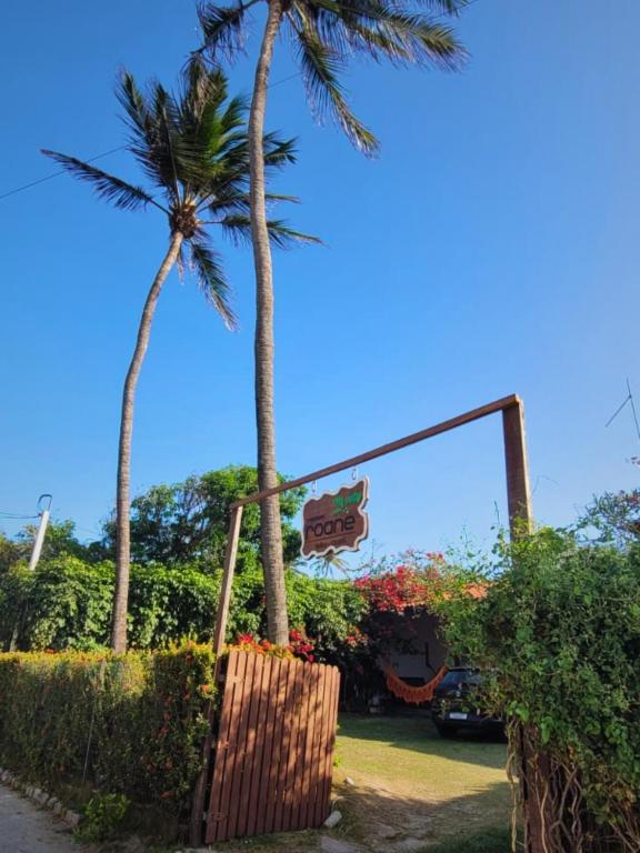 a sign for a fast food restaurant with palm trees at Pousada Roane - Taíba in Taíba