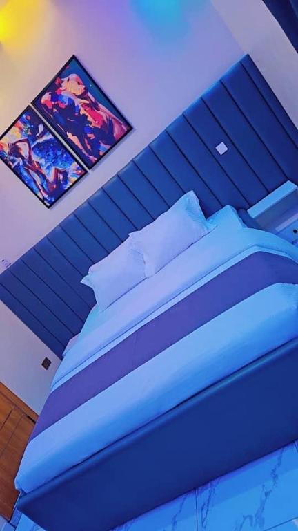 a bedroom with a blue bed in a room at Postive Vibes Hotel and Bar in Ikotun