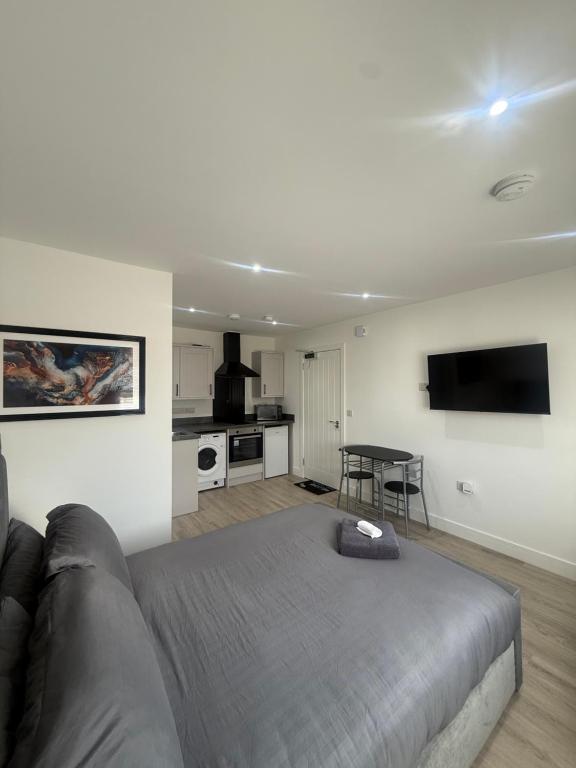 a living room with a bed and a kitchen at CoolSideOfThePillow in Swindon