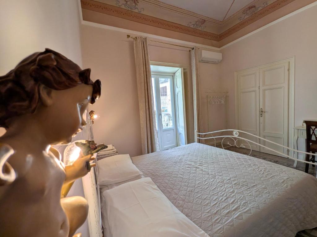 a bedroom with a bed with a doll sitting on it at A Casa ra Signurina in Modica