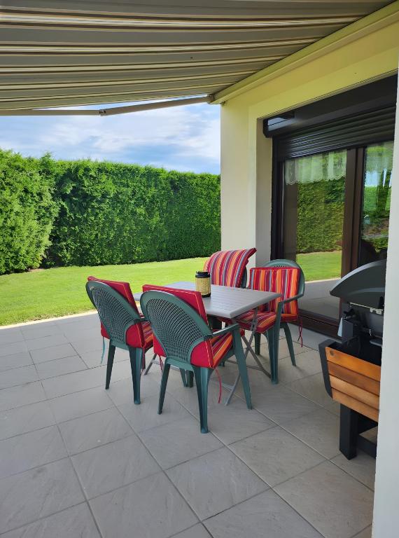 a patio with a table and chairs and a grill at Chez Marie et Guy 