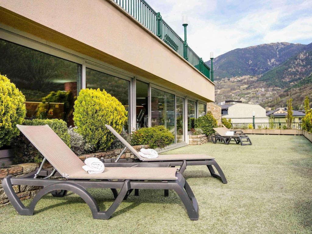 two lounge chairs and a table on a patio at Mercure Andorra in Andorra la Vella