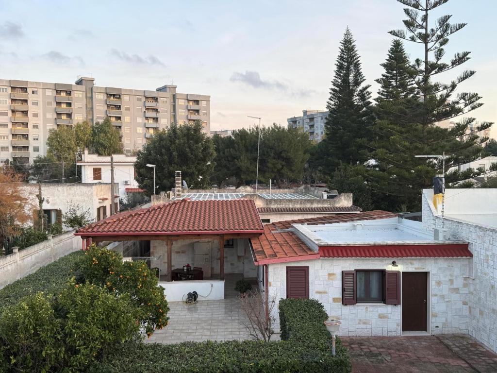 a small house with a red roof in a city at Dal Cappellaio Matto in Taranto