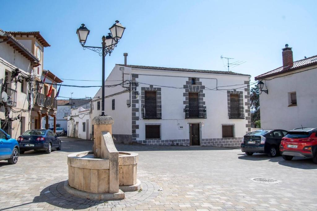 a building with cars parked in a parking lot at Casona del Tajuña in Armuña de Tajuña
