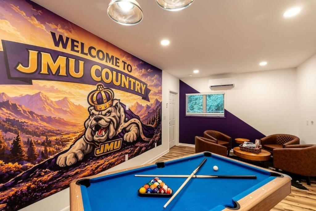 a pool table in a room with a welcome to jimmy country mural at Cedar Retreat in McGaheysville
