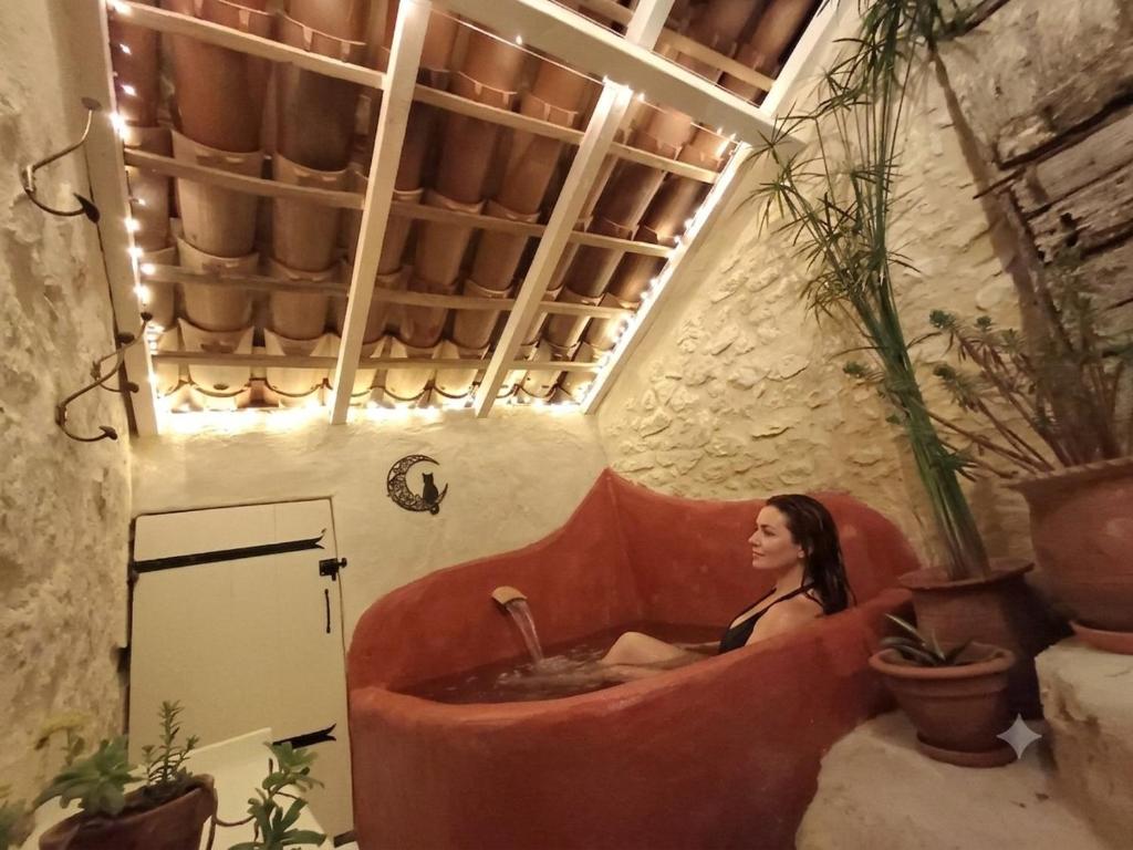 a woman sitting in a tub in a room at Moon in Flaugnac