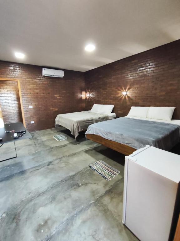 a hotel room with two beds and a television at Hotéis Online in Boa Vista