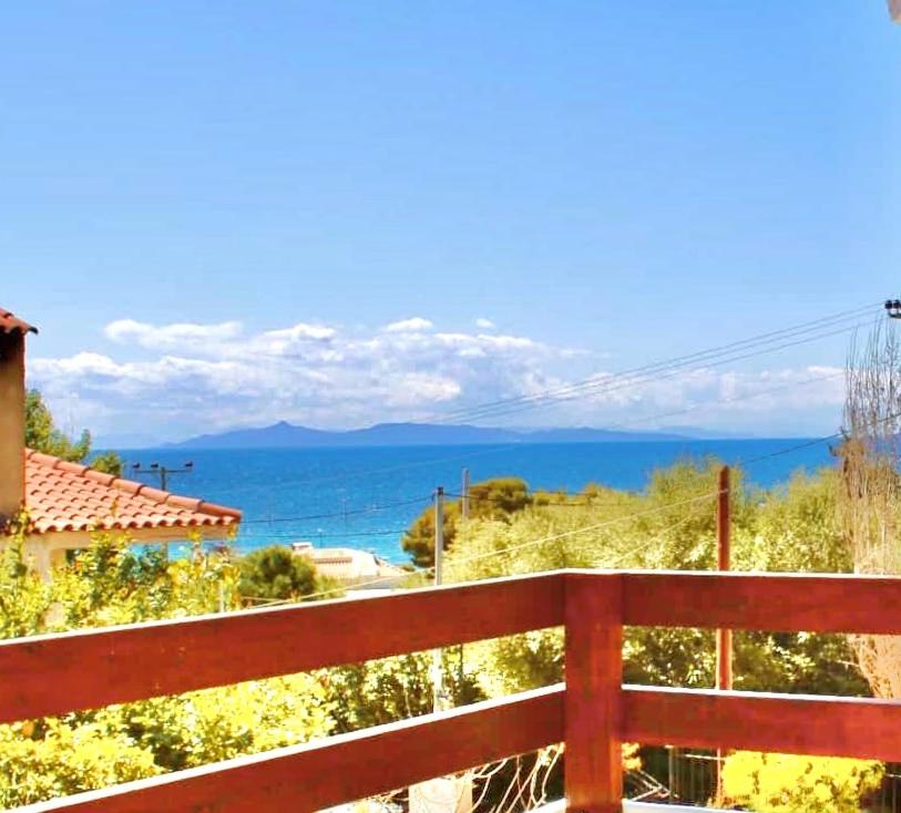 a red fence with a view of the ocean at Villa Naya by the Beach in Anavyssos