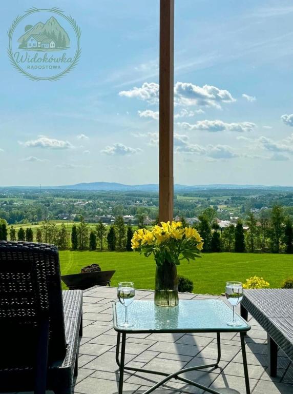 a table with a vase of flowers on a patio at Widokówka Radostowa in Podmąchocice